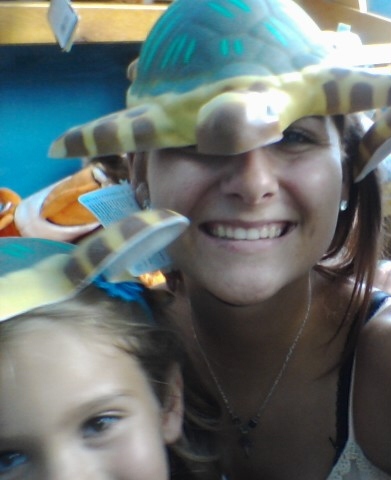 At Mote Marine trying on hats at the gift store after we saw the dolphins